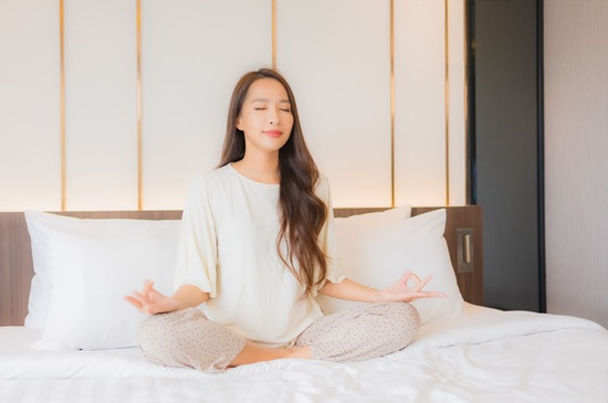 recreational activities during pandemic - woman meditating in her bedroom