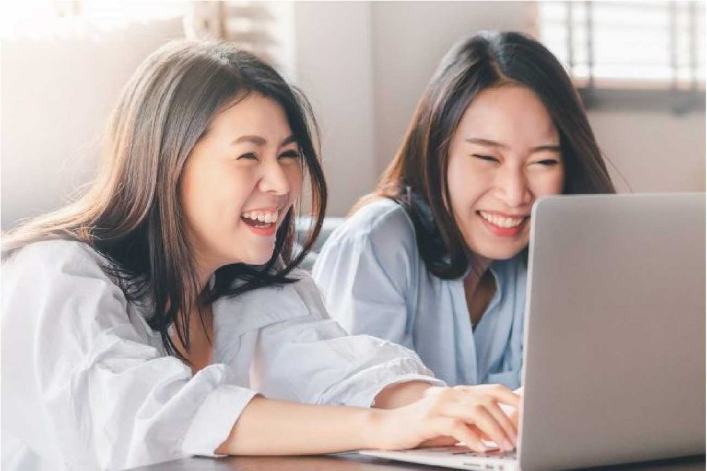 two women having good time in their laptop